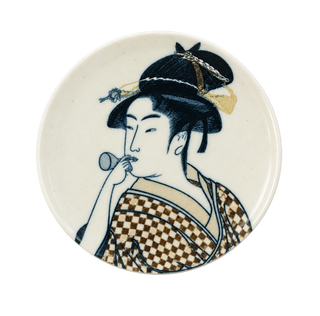 A round ceramic plate featuring a traditional Japanese geisha illustration in blue, brown, and gold tones on an off-white background.